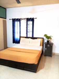 a bedroom with a large bed with blue curtains at Happy Stay in Vagamon