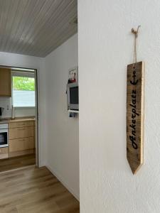 a kitchen with a sign hanging on a wall at Birkenweg Ankerplatz II in Carolinensiel