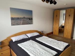 a bedroom with a bed with a picture on the wall at Birkenweg Ankerplatz II in Carolinensiel