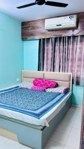a bedroom with a bed with pink pillows on it at Kaushani Homes in Nangi