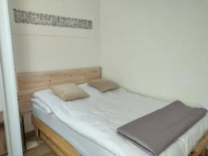 a bed with two pillows on it in a room at Apartament Art & Lake View in Gryzliny