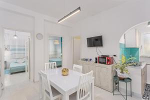 a kitchen and dining room with a white table and chairs at Villa Damiano in Tertenìa +27 photos