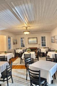 a dining room with tables and chairs and a ceiling at 07-Founders Suite at The Castle Inn in Ocracoke