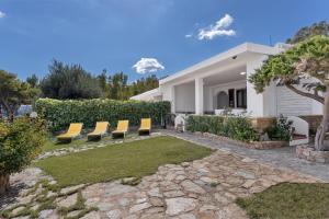 a backyard with chairs and a house at Villa Damiano in Tertenìa