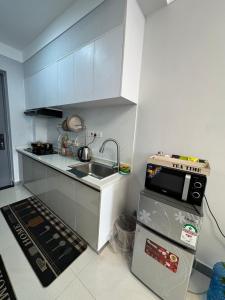 a small kitchen with a sink and a microwave at Jambo luxury living in Marimbeti