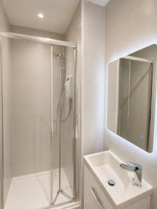 a white bathroom with a shower and a sink at Station Hotel in Burghead