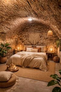 a bedroom with a large bed in a stone wall at La Demeure de Gaïa in Chalon-sur-Saône