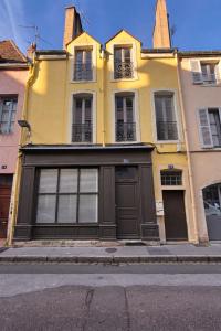 a yellow house with a garage on a street at La Demeure de Gaïa in Chalon-sur-Saône