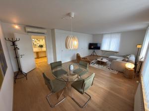 a living room with a glass table and chairs at Stadtloft Suites Zürich- Oerlikon in Zurich