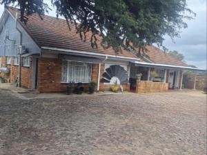 a brick house with a large driveway in front of it at Schweizer Lodge in Schweizer-Reineke