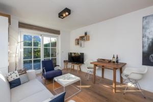 a living room with a white couch and a table at Welcome in - Appartement met zonnig terras, nabij centrum Zoutelande I Borne 56a in Zoutelande