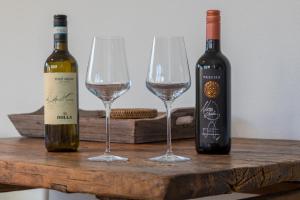 two bottles of wine and two glasses on a wooden table at Welcome in - Appartement met zonnig terras, nabij centrum Zoutelande I Borne 56a in Zoutelande