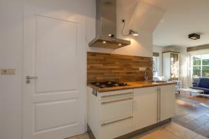 a kitchen with a stove top oven next to a door at Welcome in - Appartement met zonnig terras, nabij centrum Zoutelande I Borne 56a in Zoutelande