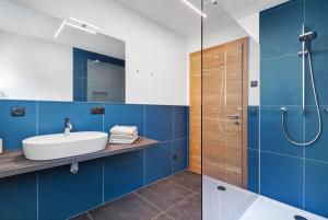 a bathroom with blue walls and a sink and a shower at Nature House Pflersch in Brennero +144 photos