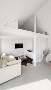 a white living room with a couch and a bed at Scandinavian Guesthouse, Archipelago Escape in Vaxholm