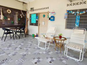 a patio with two chairs and a table at The Hidden Gems in Pantai Cenang