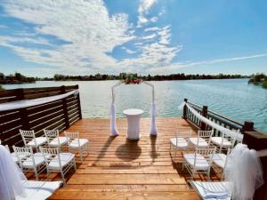 a wooden deck with chairs and an altar on the water at Hotel Zátoka in Senec +71 photos