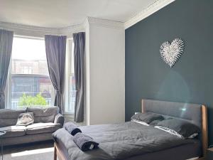 a bedroom with a bed and a couch and a window at Myrtle Villas in Hull +28 photos