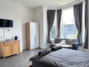 a bedroom with a bed and a tv and a couch at Myrtle Villas in Hull