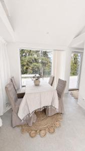 a white dining room with a table and chairs at Scandinavian Guesthouse, Archipelago Escape in Vaxholm