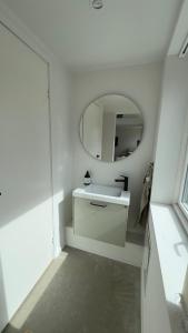 a white bathroom with a sink and a mirror at Scandinavian Guesthouse, Archipelago Escape in Vaxholm