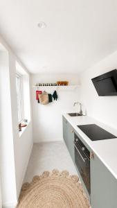 a kitchen with white counters and a sink and a rug at Scandinavian Guesthouse, Archipelago Escape in Vaxholm +11 photos