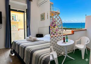 a bedroom with a bed and a table with a view of the ocean at Baron Beach Hotel in Scauri