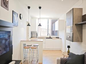a kitchen with white cabinets and bar stools at La Terrazza del Gabbiano in Cozze