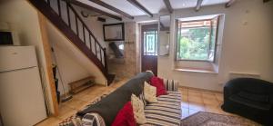 a living room with a couch and a staircase at Le Quereau in Saint-Macoux