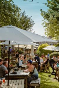a group of people sitting at tables under an umbrella at Bankes Arms Hotel in Wareham