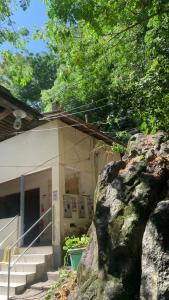 a building with a large rock in front of it at Hostel da Floresta in Vitória