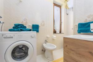 a bathroom with a washing machine and a toilet at Villa Damiano in Tertenìa