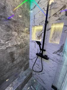 a light pole in a room with a marble wall at Mini Studio Aristocrat in Târgovişte +17 photos