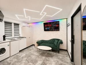 a living room with a green couch and a table at Mini Studio Aristocrat in Târgovişte
