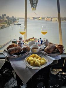 a table with plates of food and glasses of wine at Faralda Crane Hotel in Amsterdam
