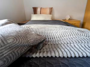 a bedroom with a bed with a comforter at EifelRuhe 3 in Hellenthal - ideal für Familien und Paare mit Hund - voll ausgestattete Küche und zwei Schlafzimmer in Hellenthal