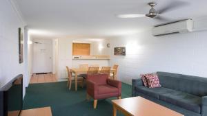 a living room with a couch and a table and chairs at Cedar Lake Country Resort in Nerang