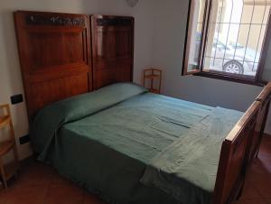a bedroom with a green bed and a window at La finestra sulla campana in Brescello