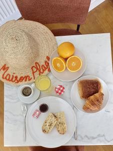 a table with plates of breakfast food on it at Maison Plage - boutique hôtel in Saint-Brevin-les-Pins