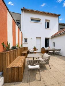 a patio with tables and chairs and a fence at Maison Plage - boutique hôtel in Saint-Brevin-les-Pins