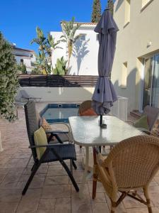 a table and chairs with an umbrella on a patio at Villa Flory in Protaras
