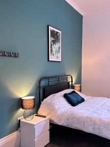 a bedroom with a bed and a blue wall at Myrtle Villas in Hull