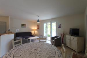 a living room with a table and a couch at Clos Christol in Graveson
