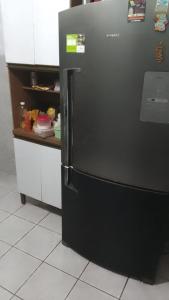 a black refrigerator in a kitchen with a counter at Hostel da Floresta in Vitória