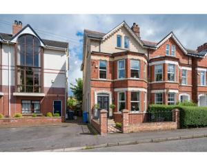 a large brick house on a street at Ormeau Park Residence in Belfast