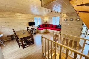 a living room with a red couch and a table at Chalet le Petit Coeur in Xonrupt-Longemer