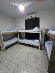 a room with three bunk beds and a ceiling at Hostel da Floresta in Vitória