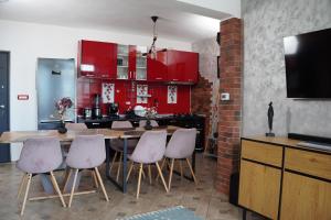 a kitchen with red cabinets and a wooden table and chairs at Casa Corina Dubova in Dubova