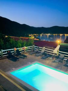 a swimming pool with chairs and a view of the water at Casa Corina Dubova in Dubova