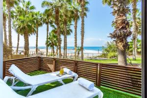 eine Terrasse mit Tisch und Stühlen und der Strand in der Unterkunft Daniel Herzliya Hotel in Herzlia